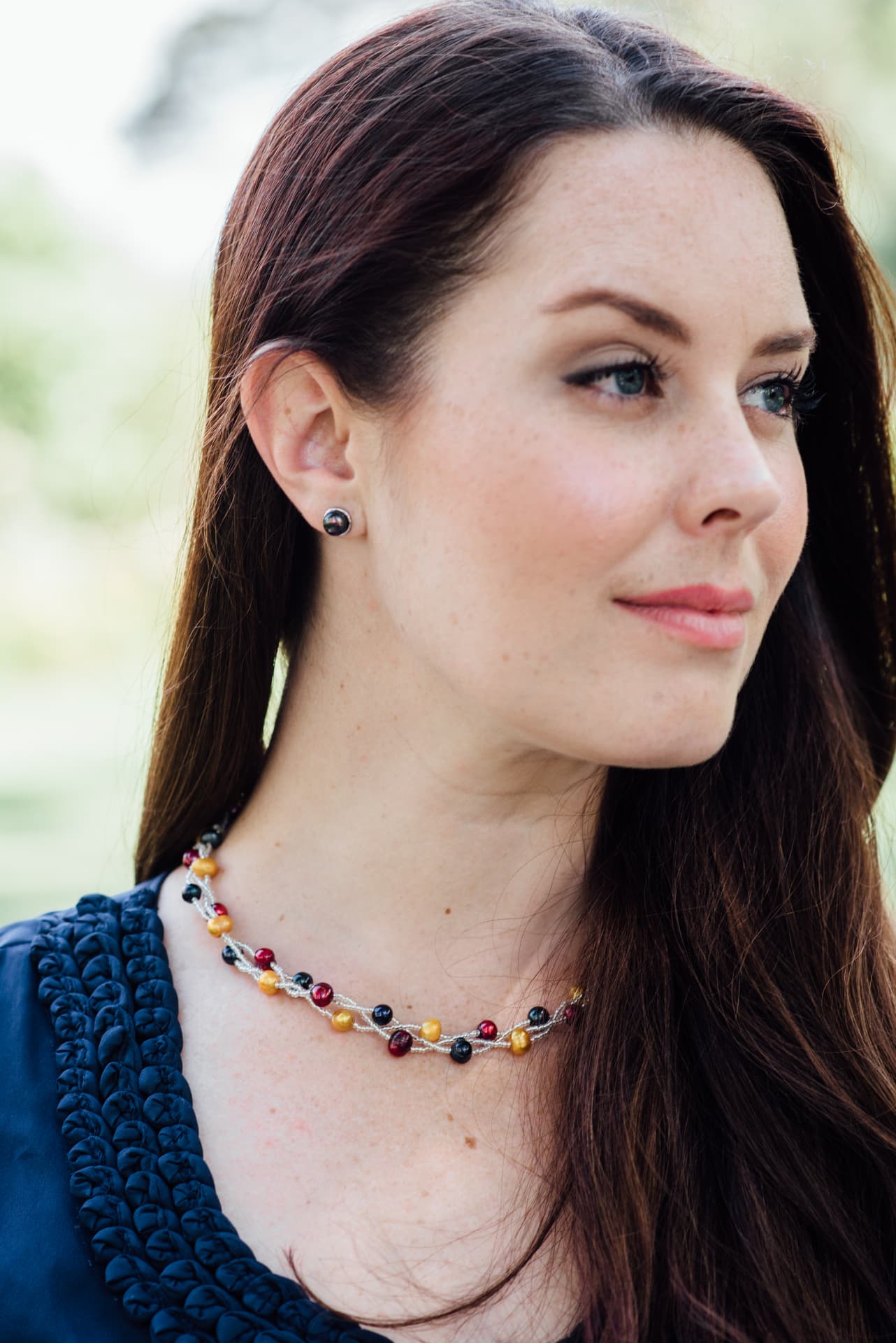 Woman wearing a multi-strand freshwater pearl necklace and pearl stud earrings